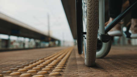 Low angle, close up of the wheels of the wheelchair on the train station. High quality photoの写真素材