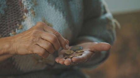 Homeless old woman counting last coins. Close up. High quality photoの写真素材