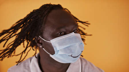 African Man with face mask and smile shaking his braided hair. High quality photoの写真素材