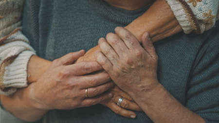 close up wrinkled hands. Happy old couple hugging in park. Senior man flirting with elderly woman. Romance at old age dancing on autumn day. High quality photoの写真素材