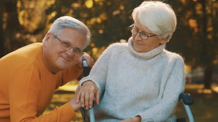Old couple having romantic autumn day in forest. Hugging tree and smiling. High quality photoの写真素材