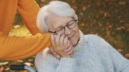 Old couple having romantic autumn day in forest. Hugging tree and smiling. High quality photo
