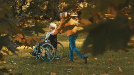 Old couple having romantic autumn day in forest. Hugging tree and smiling. High quality photoの写真素材