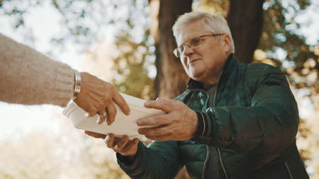 Old vulnerable homeless man getting free charity meal. High quality photoの写真素材