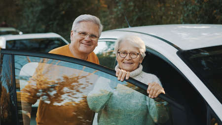 Senior couple purchased new car. Standing near the door and woman holding keys. High quality photoの写真素材