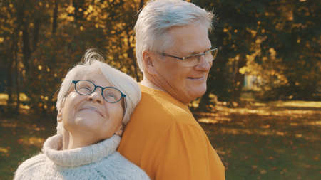 Love and affection at old age. Retired couple enjoying autumn day in forest. High quality photo