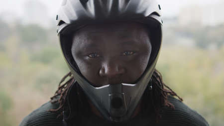 African Man Wearing The Motorbike Protective Helmet Looking to the Camera. High quality photoの写真素材