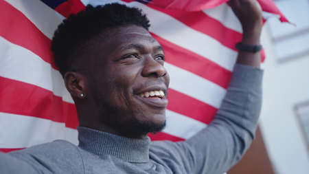 Black man african-american with USA flag on the balcony.の写真素材