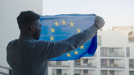 Young attractive black man waving European Union flag. High quality photo