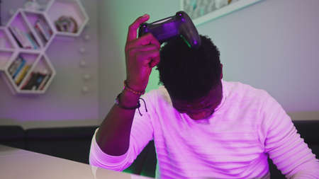 Black man playing game using console controlling joystick. Entertainment during the lockdown. Lost...