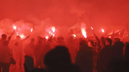Warsaw, Poland 11.11.2020 - Independence day march on 102nd anniversary in Warsaw. People marching in the red smoke. High quality photoのeditorial素材