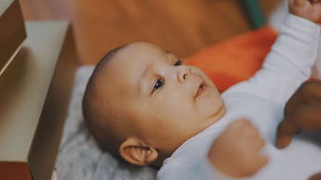 Adorable baby holding father hand. Mulatto baby playing with fathers hand. close up. High quality...
