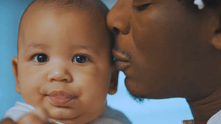 Close up, african american black father kissing his baby. High quality photoの写真素材