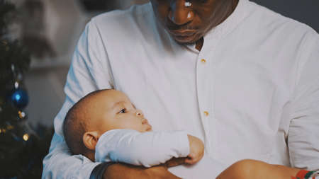 Happy family concept. Young african american black father holding his mulatto baby. High quality...