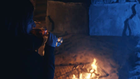 Young woman drinking mulled wine ear the fireplace on winter evening. High quality photo