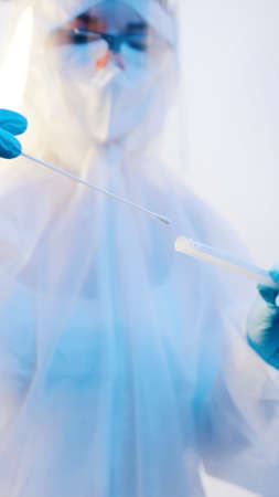 Nurse in full protective suit performing nasal swab test. High quality photoの写真素材