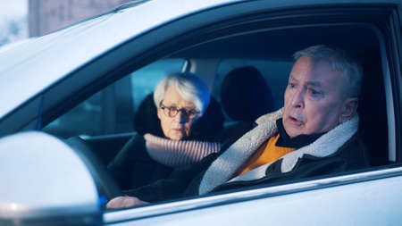 Elderly couple in the car confused with flashing police lights. Speeding ticket. High quality photoの写真素材