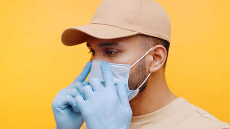 Young man adjusting medical face mask. Prevention of the  spread. High quality photo