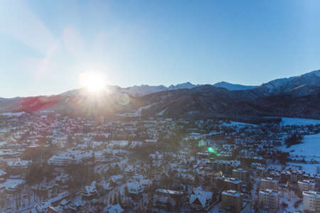 Winter season in Zakopane, Poland. Snow covered houses roads and forest with mountains in the background. High quality photoの写真素材