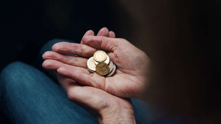 Wrinkled hands of elderly woman counting coins. Close up. High quality photoの写真素材