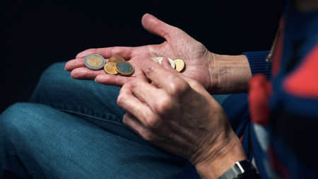 Old woman counting coins in her wrinkled hands. Close up. High quality photoの写真素材
