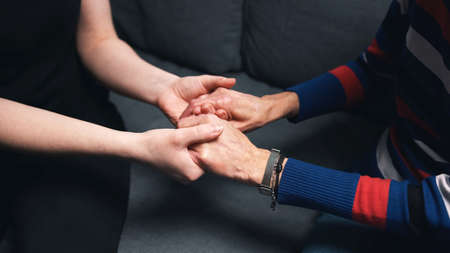 Young person holding hands of an elderly woman. High quality photoの写真素材
