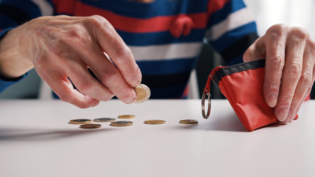 Poor old woman counting coins on the table. Low pension and insufficient funds. High quality photo