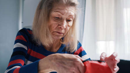 Poor old woman counting coins on the table. Low pension and insufficient funds. High quality photoの写真素材