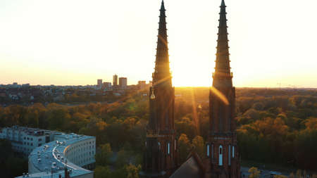 Warsaw, Poland 12.01.2020 - Front View of Cathedral of St. Michael the Archangel and St. Florian the Martyr. Sunset view. Sun rays hitting the church. Trees in the background against the clear sky.のeditorial素材