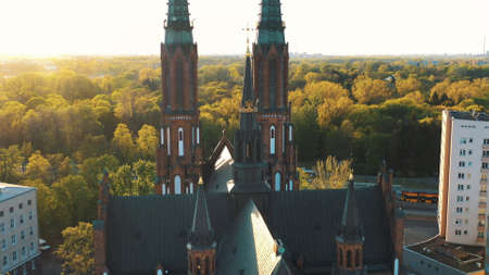 Warsaw, Poland 12.01.2020 - Back view of Cathedral of St. Michael the Archangel and St. Florian the Martyr. Beautiful green trees in the background. Sunlight can be seen through the trees.のeditorial素材