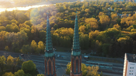 Warsaw, Poland 12.01.2020 - Aerial view of Twin towers of Cathedral of St. Michael the Archangel and St. Florian the Martyr. Sunlight striking the lush green trees in the background. The shot is taken during the evening.の写真素材