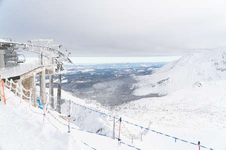 Kasprowy Wierch, Poland 28.01.2021 - Tatra Mountains in winter. Snow-Covered Sloppy area. Picturesque white sky in the background. Snowy mountains can be seen on the right side. Weather Station.のeditorial素材