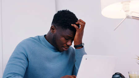 Stressed out man working on his laptop. Work stress or work load concept. High quality photoの写真素材