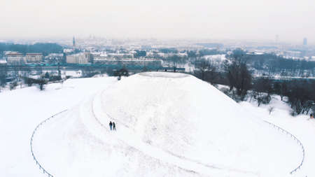Panoramic view of the Krakus Mound (Kopiec Krakusa) also called Krak Mound. A tumulus located in the PodgÃ³rze district of KrakÃ³w, Poland. Tourists can be seen standing. Whole area covered with snow.の写真素材