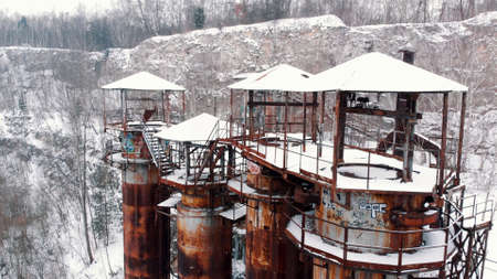 Liban quarry Kamieniolom in Krakow, Poland during the winter season. Old rusty machinery and piping equipment in closed limestone. Jurassic limestone cliffs and old, rusty industrial buildings.の写真素材