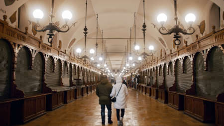 Krakow, Poland 03.02.2021 Inside view of Krakow Cloth Hall the most famous building in the middle of the Old town. Locals and tourists inside the cloth hall walking along with the closed stalls.のeditorial素材