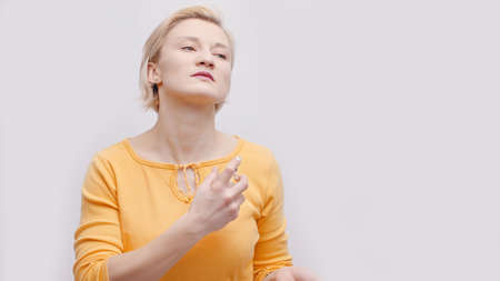 A blonde girl dressed in a bright yellow top isolated over a white background studio shot. Girl...