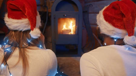a couple in love stares at the flames of the fire from the furnace. High quality photoの写真素材