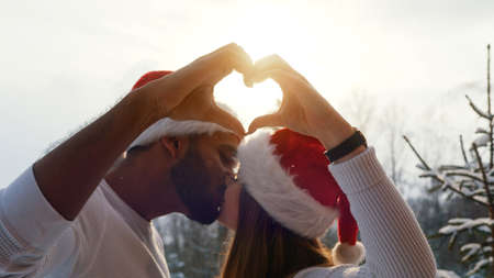 the young couple shows that it is brighter than the sky in the sign of the heart. High-quality photo
