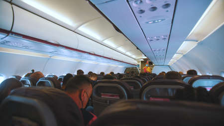Benidorm, Spain 18.08.2021 Interior of a large modern Airplane with passengers wearing masks sitting in the seats. The shot is taken from inside the plane. Travel during Covid Concept.のeditorial素材
