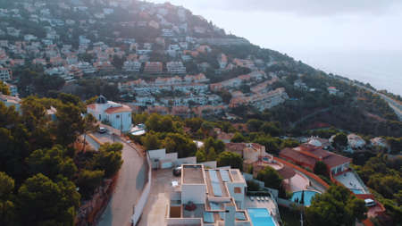 Altea Hills, Spain 18.08.2021 Cityscape on the coast of Altea, Alicante Province and mountains on the Costa Blanca of Spain. Mountains in the background touching clear white sky. Daytime Shot.のeditorial素材