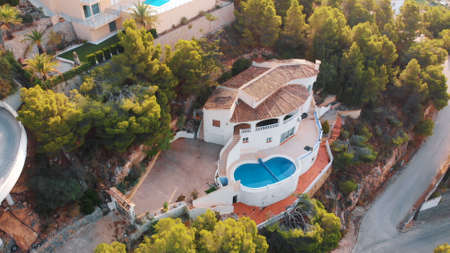 Altea Hills, Spain 18.08.2021 - Aerial shot of the beautiful holiday villas at Altea Hills. A famous tourist spot in the city. Surrounded by lush green trees. The shot is taken in the daytime.のeditorial素材