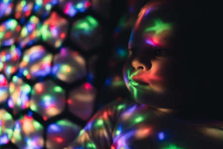 Galaxy Lighting Projector Concept. Little baby discovers the world of magical technology. High quality photoの写真素材