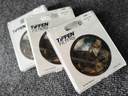 04.10.2021 Warsaw, Poland. Three packed Tiffen Promist Filters over textured grey background. High quality photoのeditorial素材