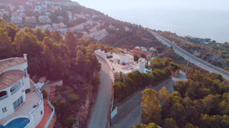 view from a height of a hill with lots of houses, roads, and an open sea. High-quality photoの写真素材