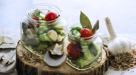 Mushrooms garlic cucumber tomato pepper in a jar.の写真素材