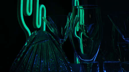 Glasses and shots highlighted by green light on a black background. Low key.の写真素材