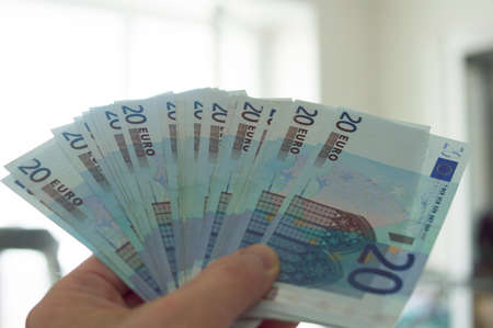 Stack of euro money in hand, twenty euro banknotes in cash