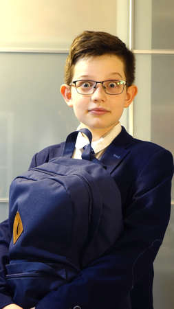 Surprised school boy with book bag in eyeglassesの写真素材