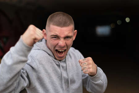 A bully guy in a light sports jacket with a hood